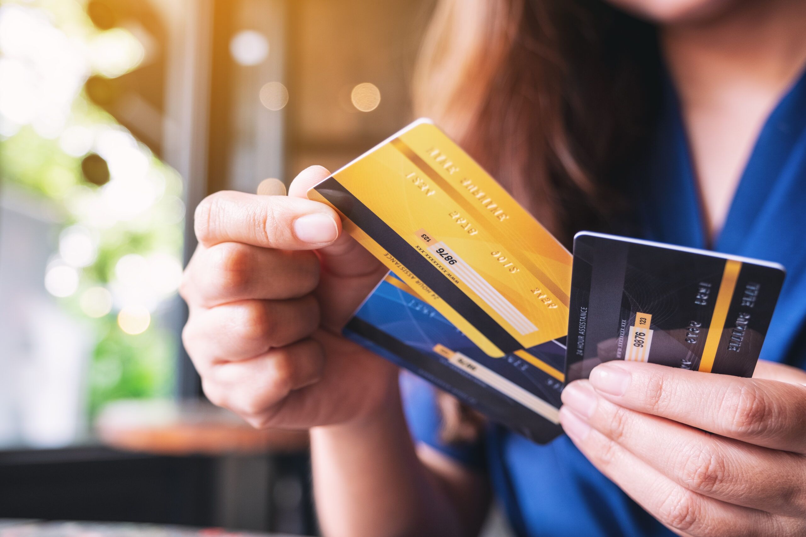 Closeup image of a woman holding and choosing credit card to use top of wallet credit card