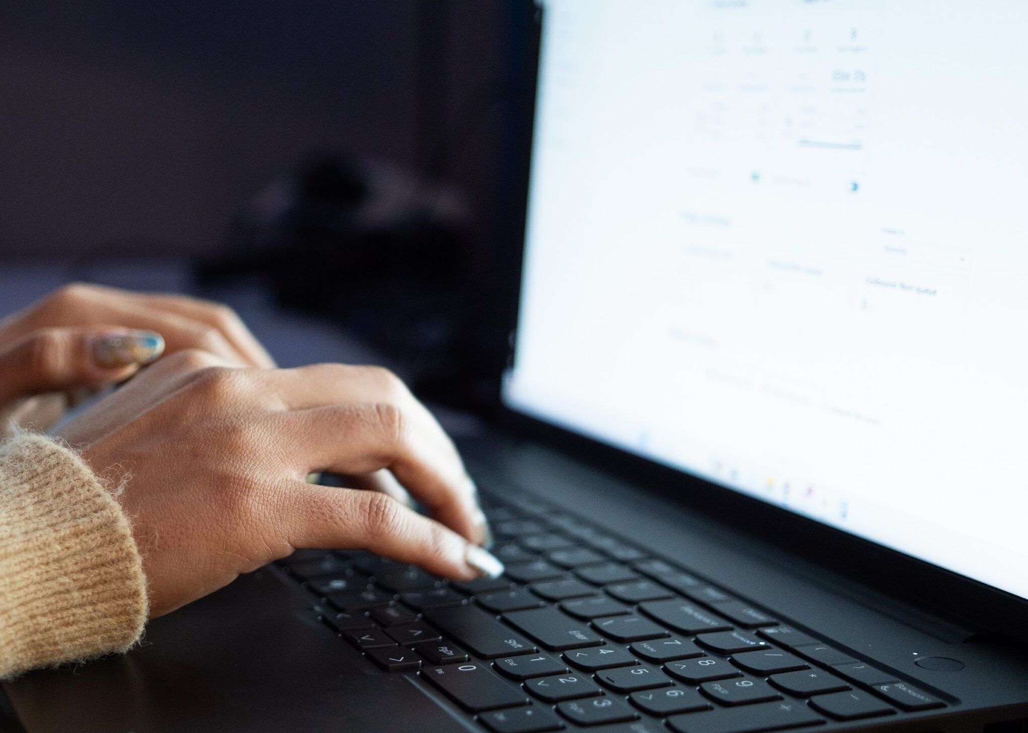 Hands typing on a laptop keyboard